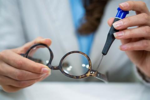 Optiker wechselt Brillengläser von einer Brille